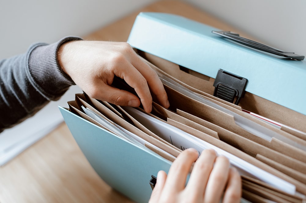 Person finding papers in his/her suit case